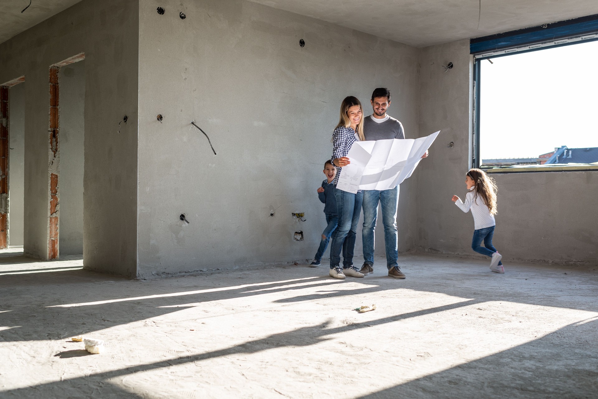 Glückliche Familie analysiert Pläne in ihrer neuen Wohnung